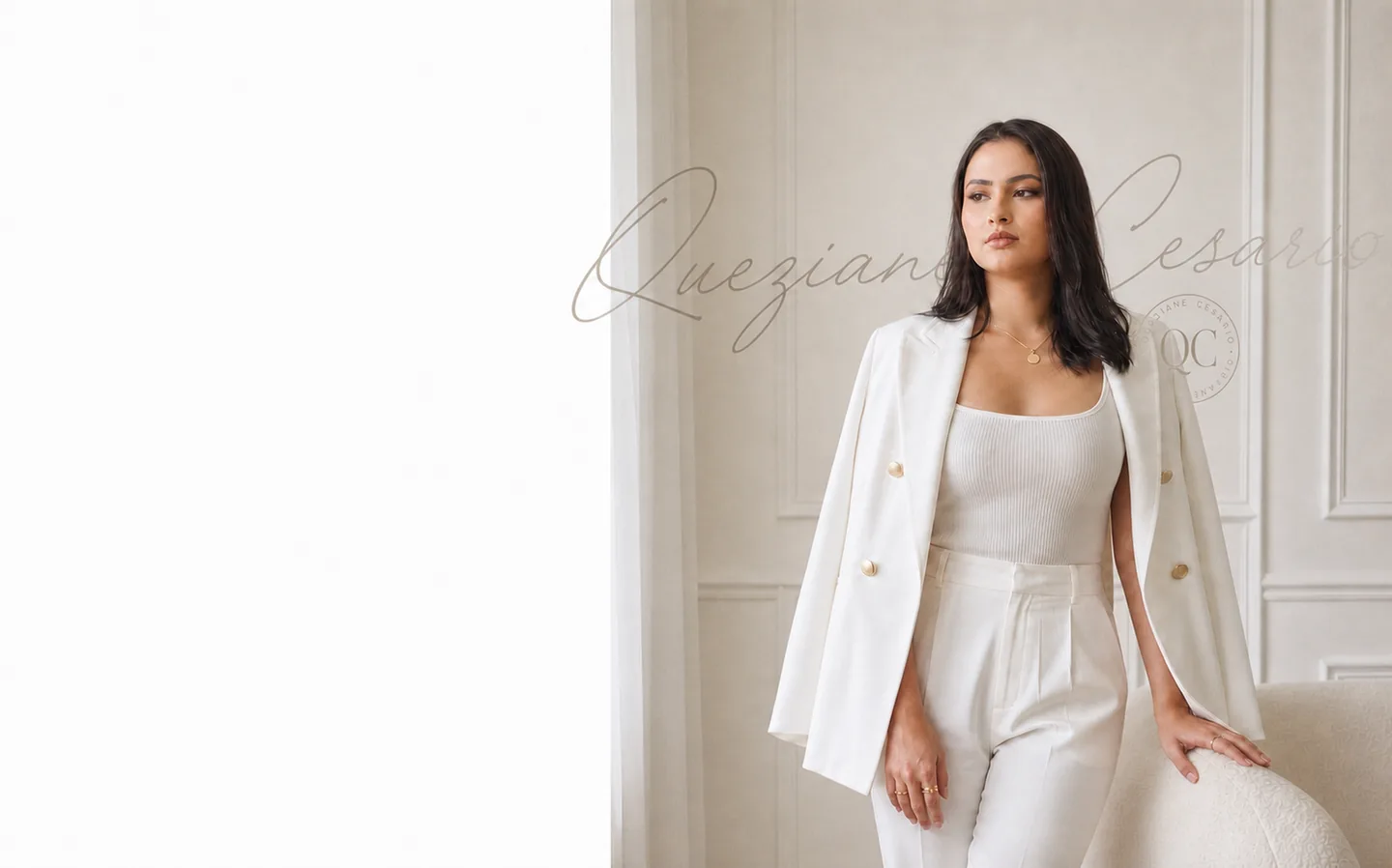 Queziane Cesario de terno branco, em pé num ambiente claro